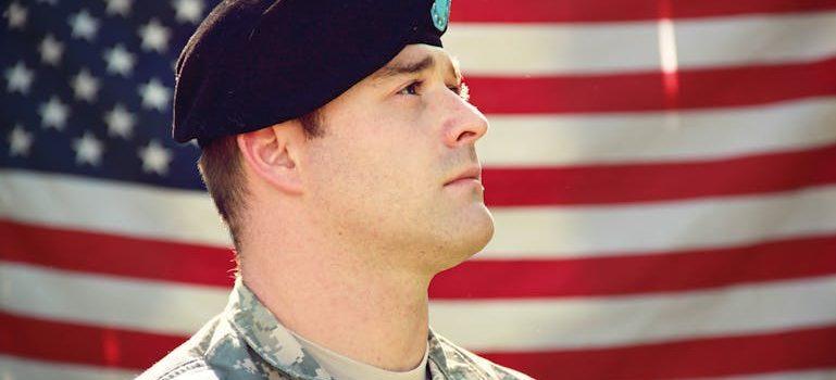 A veteran standing in front of the flag