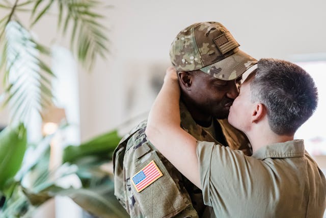 A man in a uniform kissing a woman