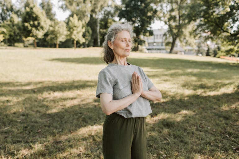 A woman meditating outdoors